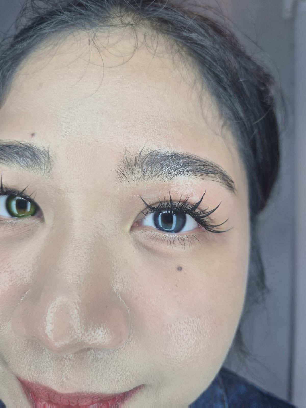 Happy client admiring her results at The Rich Brow